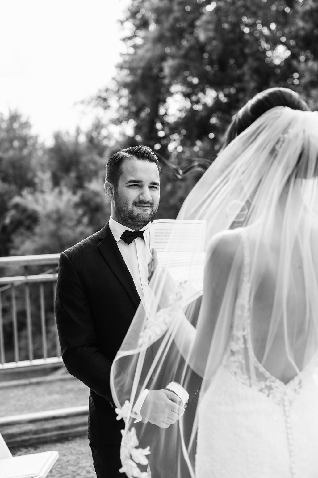 Groom standing in front of Bride at the ceremony.